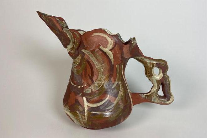 Neutral colored, ceramic pitcher with bird-like spout, wavy rim, and large curvy handle. This form was generated from line drawings of my sister (Paige) and has an abstracted painterly quality to the glaze application.